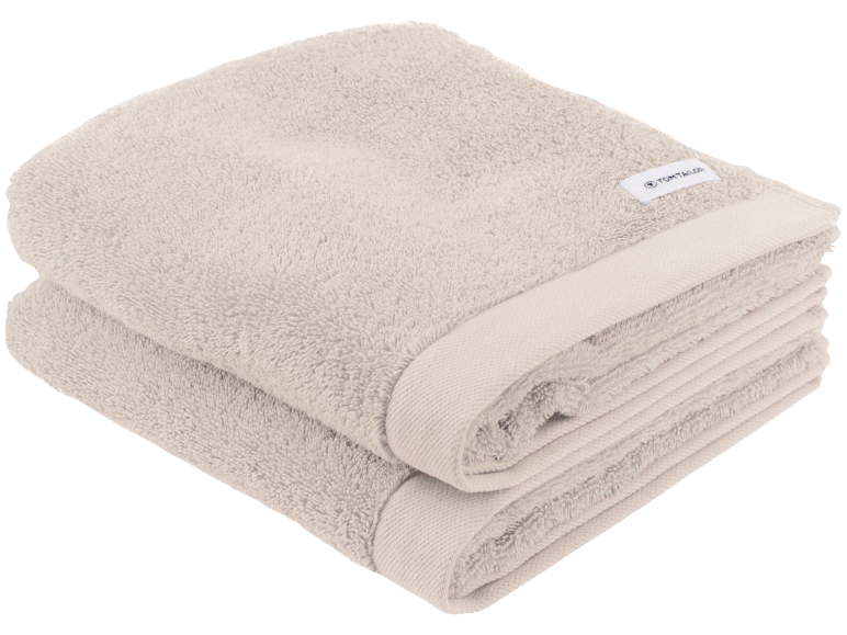 Zwei gefaltete beige Handtücher, weich und flauschig, mit dezentem Rand.
