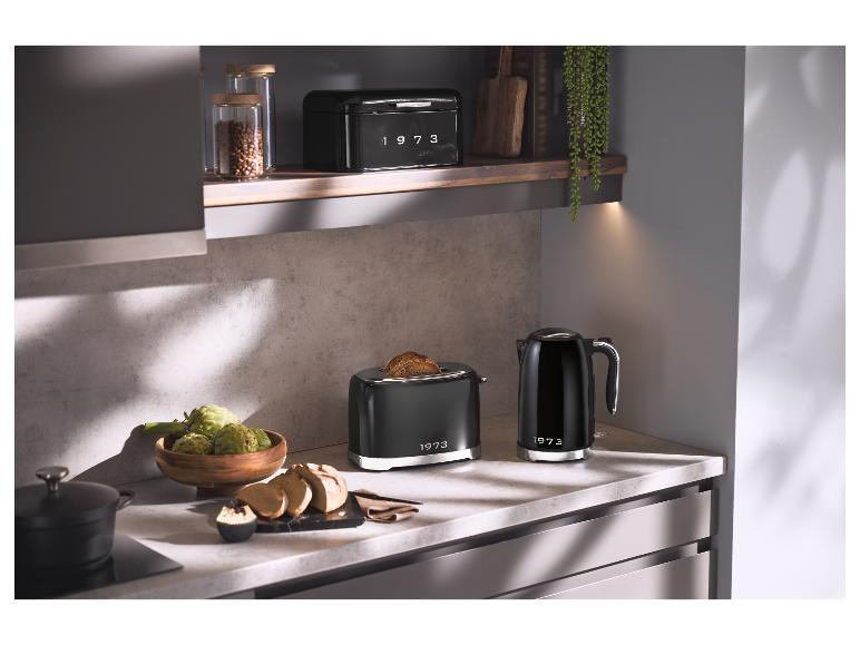 Schwarzer Toaster und Wasserkocher mit „1973“ auf einer Küchenarbeitsplatte.