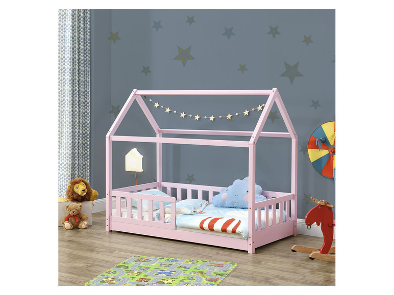 Ein rosafarbenes Kinderbett in Form eines Hauses mit Himmelbett.