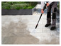 Eine Person reinigt eine Stein terrasse mit einem Parkside Hochdruckreiniger.
