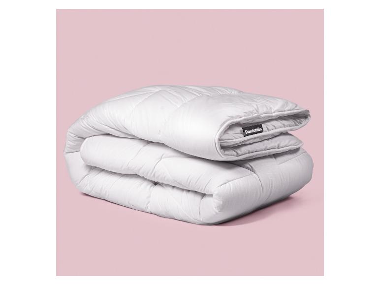 Weiße Dunlopillo-Bettdecke gefaltet auf rosa Hintergrund.