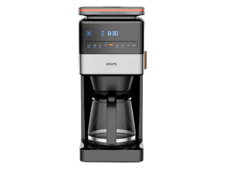 Kaffeemaschine mit Digitalanzeige 8:30, Glaskanne und orangefarbenen Akzenten.