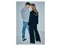 Mann in grauem Sweatshirt und Jeans, Frau in schwarzem Sweatshirt und weiter Hose, mit „TRENEISE BLUE“ auf dem Rücken.