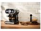 Schwarze Espressomaschine brüht zwei Kaffees, mit Keksen und Kaffeebohnen.