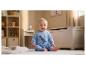 Baby in blauem Dinosaurier-Outfit sitzt in einem Spielzimmer.