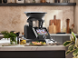 Smarte Küchenmaschine mit Touchscreen in einer modernen Küche mit zubereitetem Essen.