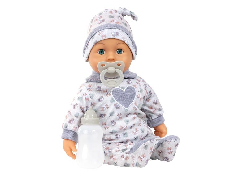 Babypuppe in gemustertem Strampler und Mütze mit Schnuller und Flasche.