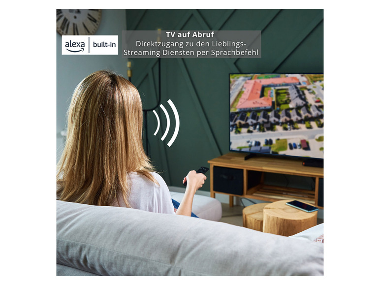 Eine Frau schaut fern mit einem Alexa-gestützten Smart-TV.