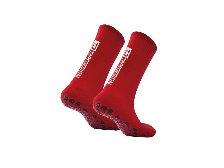 Ein Paar rote TAPEDESIGN Sportsocken mit Anti-Rutsch-Noppen.