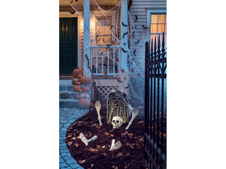Halloween-Veranda mit Kürbissen, Spinnweben, Fledermäusen und Skelett-Dekorationen.