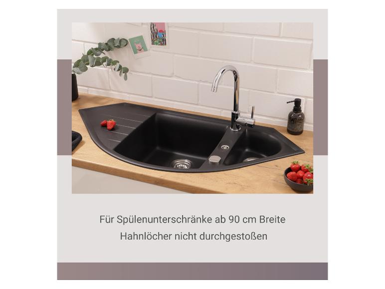 Schwarze Küchenspüle mit Wasserhahn auf Holzplatte, Erdbeeren, Eukalyptus.
