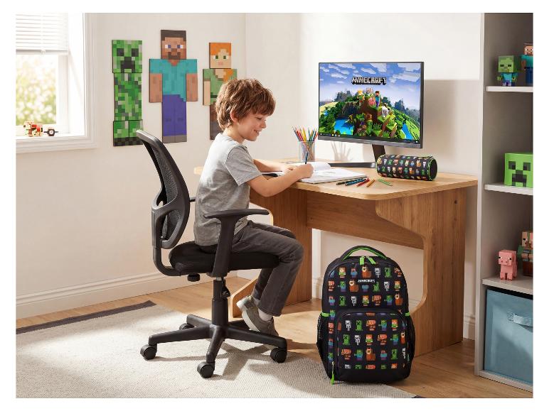 Junge zeichnet an einem Holzschreibtisch mit Rucksack und Videospiel-Deko.