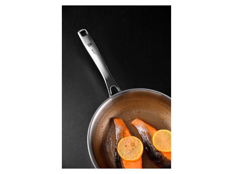 Pfanne mit Lachs und Zitrone auf schwarzem Hintergrund