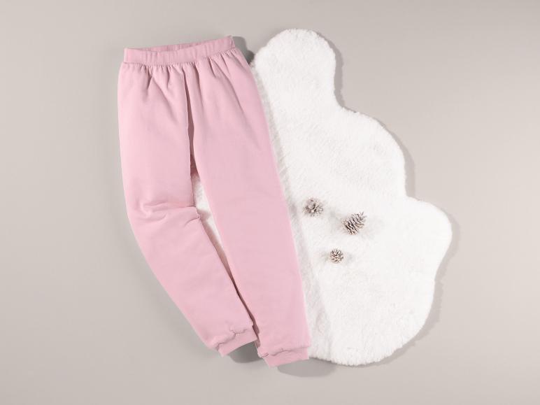Rosa Jogginghose und ein weißer Teppich mit dekorativen Tannenzapfen.
