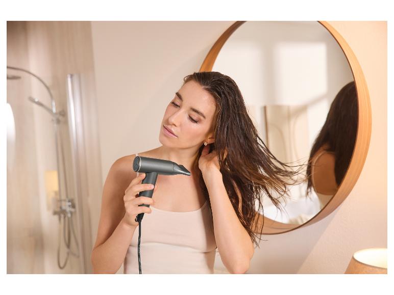 Eine Frau trocknet ihr nasses Haar mit dem Cien Premium Haartrockner UltraLite Pro