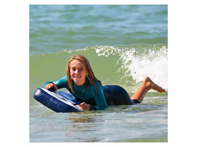 Mädchen mit einem Bodyboard im Wasser.