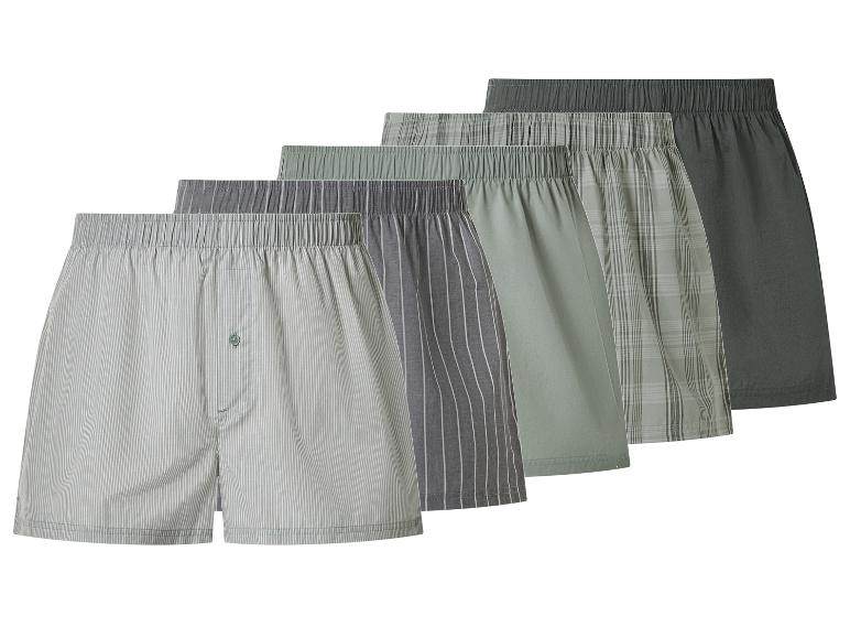 Fünf Herren-Boxershorts in verschiedenen Grau- und Grüntönen und Mustern.