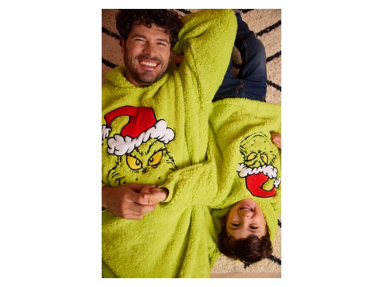 Lächelnder Vater und Sohn in passenden flauschigen Grinch-Hoodies