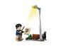 LEGO Harry Potter Minifigur mit Zauberstab, Zeitung und einem schwarzen Hund unter einer Straßenlaterne.