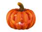 Orangefarbener geschnitzter Halloween-Kürbis mit brennender Kerze im Inneren.