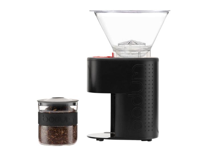 Schwarze Kaffeemühle und Glasbehälter mit gemahlenem Kaffee auf weißem Hintergrund.