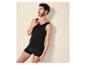 Mann in schwarzem Tanktop und Boxershorts, blickt nach rechts.