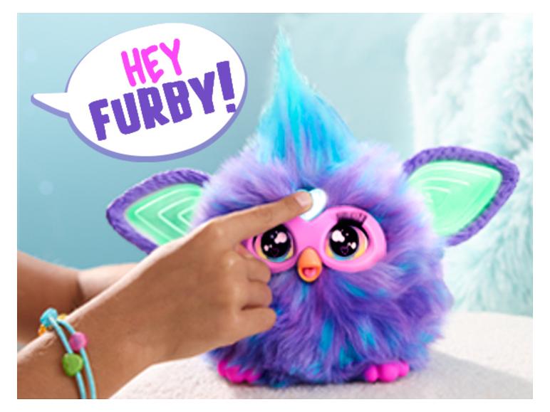 Ein Kind berührt ein lila-blaues Furby mit einer Sprechblase „HEY FURBY!“
