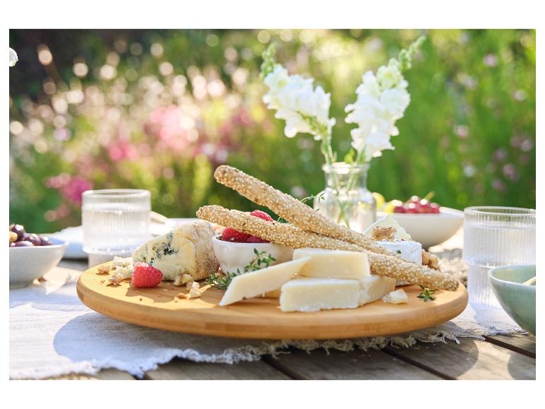 Käseplatte mit Sesamstangen und Himbeeren.