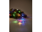 Tannenzweige mit bunten Weihnachtslichtern auf hellem Untergrund.