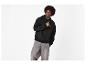 Mann in schwarzem Hoodie mit Motiv und grauer Jeans