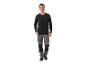 Mann in schwarzem Langarmshirt und grauer Arbeitshose.