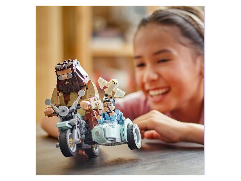 Lächelndes Mädchen spielt mit einem LEGO Harry Potter Set mit Hagrid und Harry auf einem Motorrad.