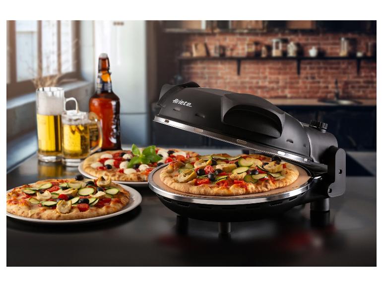 Pizza in einem Pizzaofen, zwei Pizzen auf Tellern und Bier auf einem Tisch.