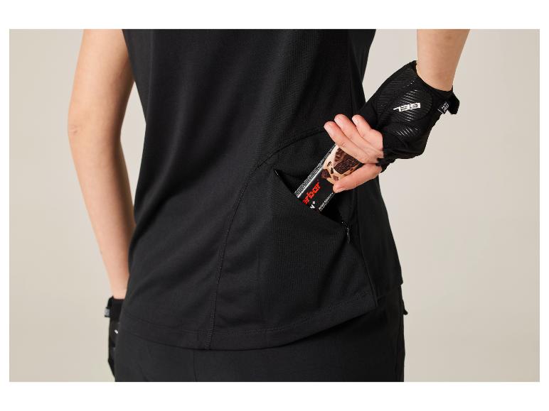 Frau in schwarzem Oberteil und Handschuhen, nimmt einen Energieriegel aus einer Seitentasche.