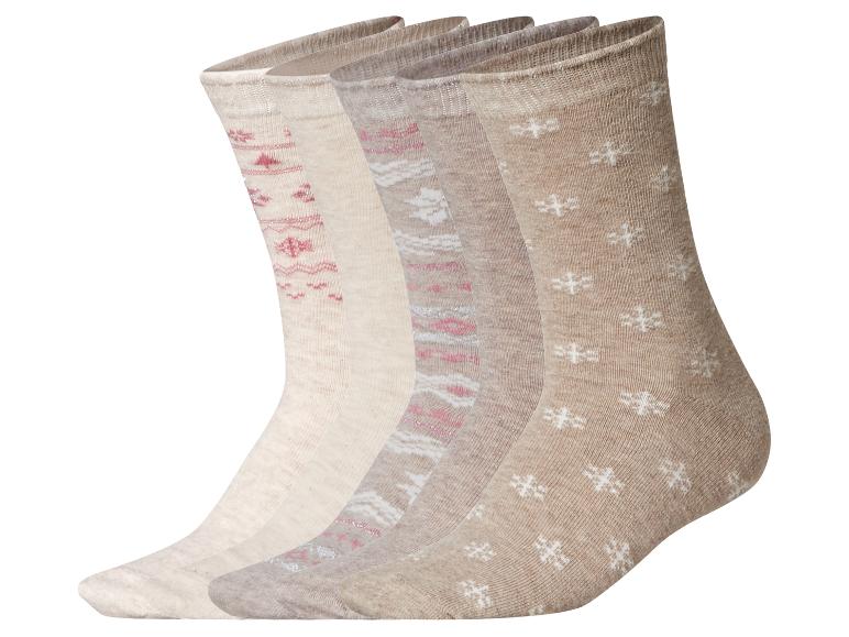 Set aus fünf Paar beigen Socken mit verschiedenen Mustern, darunter rosa und weiße Schneeflocken.