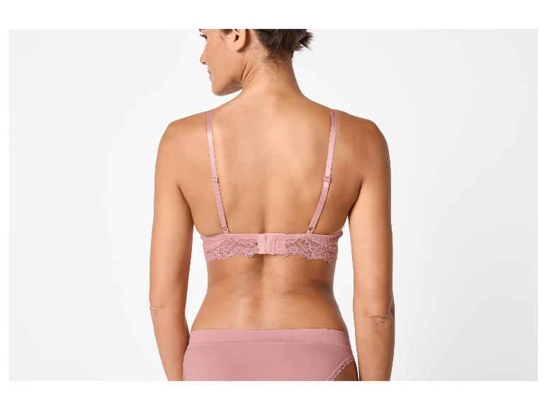 Frau in rosa Spitzen-BH und Slip, Rückansicht.