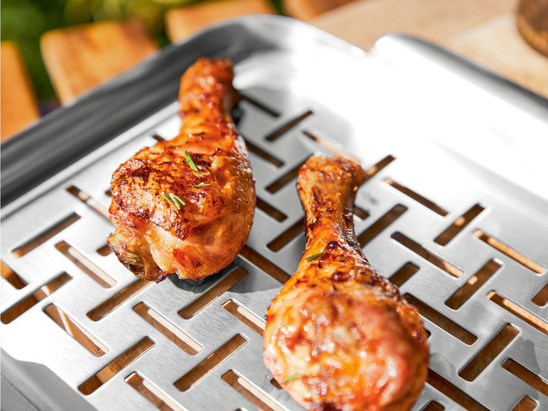 Zwei gegrillte Hähnchenschenkel auf einem Grillrost.