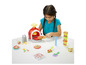 Ein Mädchen macht Pizzen mit Play-Doh-Knete und einem Spielzeugofen.