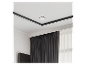 Weißer Rauchmelder an einer weißen Decke mit schwarzer Leiste, über dunklen Vorhängen und einem Fenster.