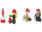 Drei Feuerwehrmann-Spielfiguren und ein Spielzeugfeuer auf weißem Hintergrund.