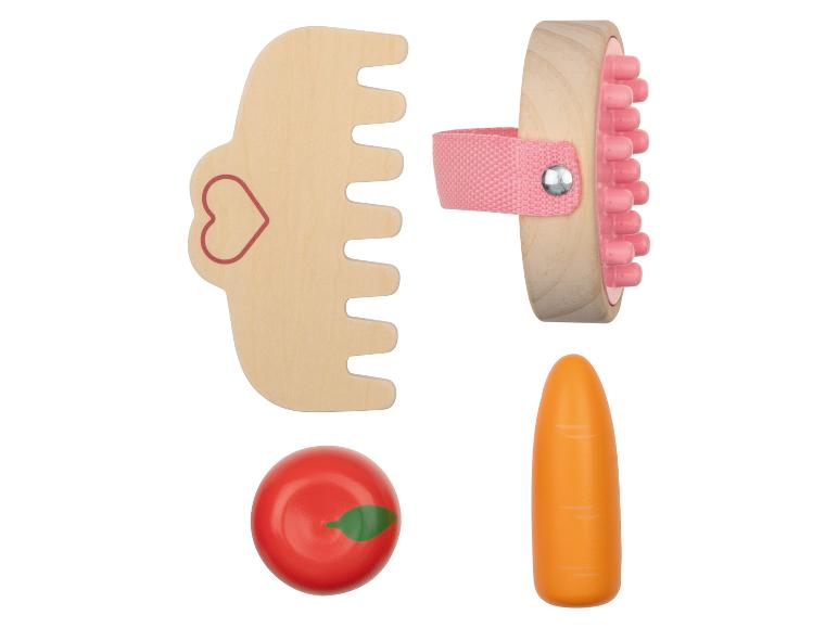 Ein Kamm, eine Bürste, ein Apfel und eine Karotte aus Holz.