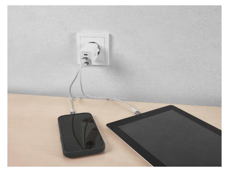 PD 45W Netzladegerät lädt Telefon und Tablet auf einem Holztisch.