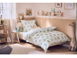 Gemütliches Kinderzimmer mit einem Bett mit Dinosaurier-Bettwäsche und verspielter Deko.