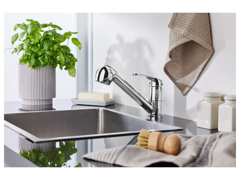 Chromarmatur, Spüle aus Edelstahl und Küchenutensilien.