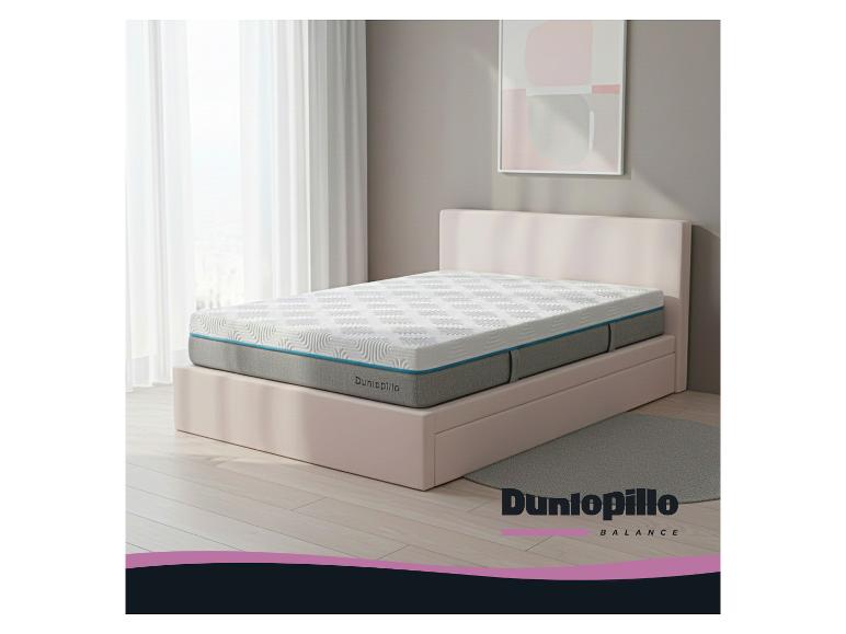 Dunlopillo Balance Matratze auf einem hellrosa Bett in einem Schlafzimmer mit weißen Vorhängen.