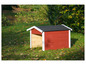 Ein rotes Holz-Hundezwinger mit schwarzem Dach auf einer Wiese mit Blättern.