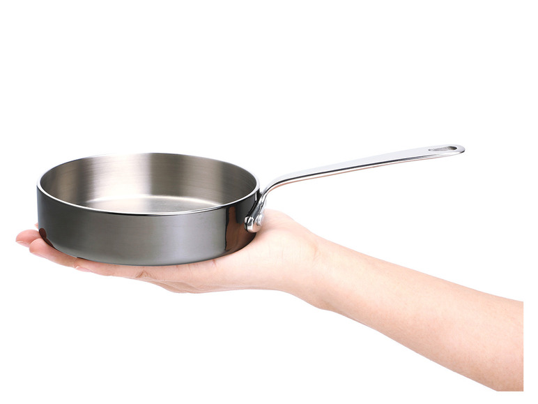 Eine Hand hält eine kleine, runde Pfanne.