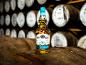 Eine Flasche Single Malt Scotch Whisky auf einem Holzfass in einer Destillerie.