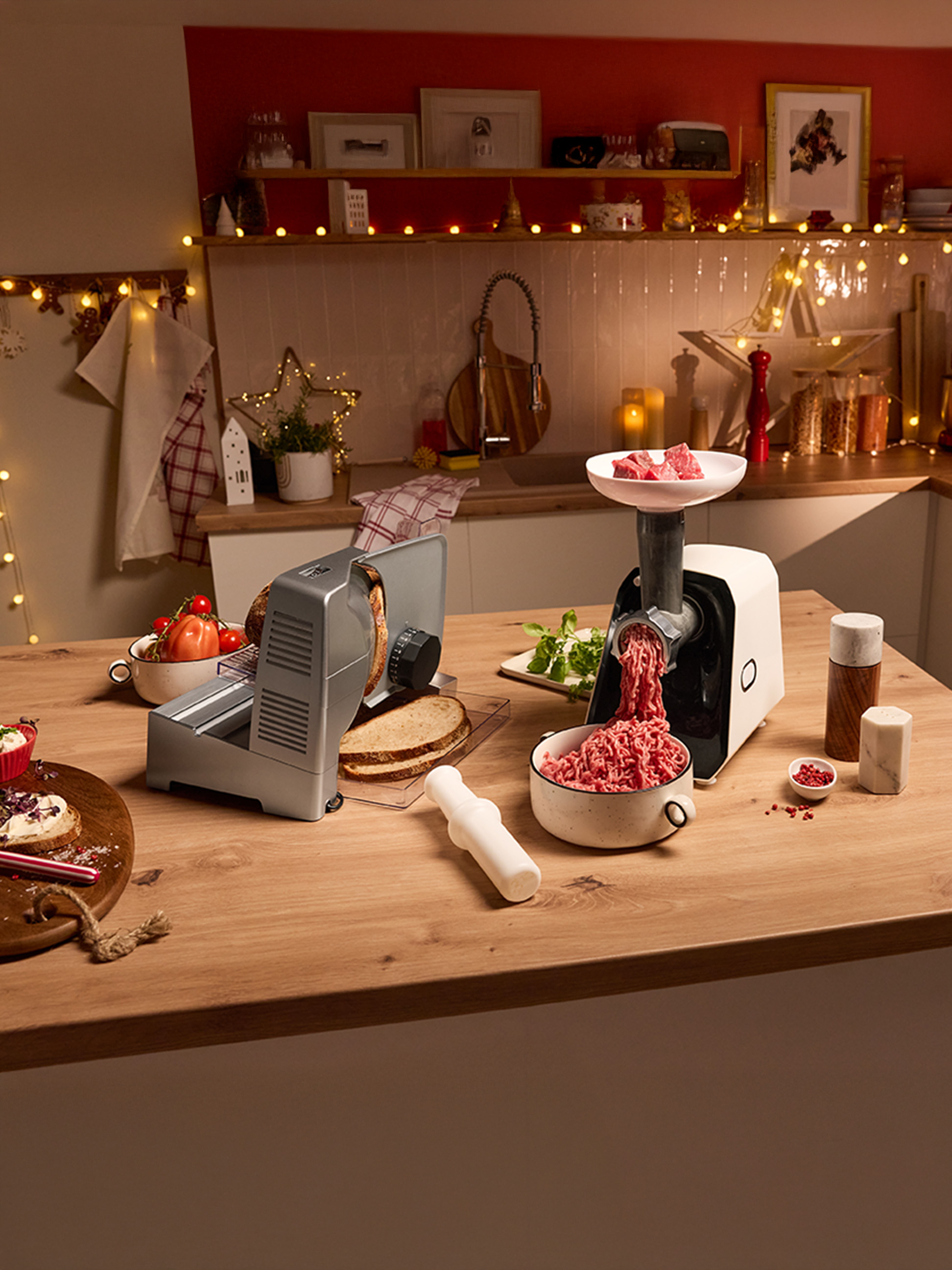 Fleischwolf und Brotschneidemaschine auf einer festlich dekorierten Küchenarbeitsplatte.