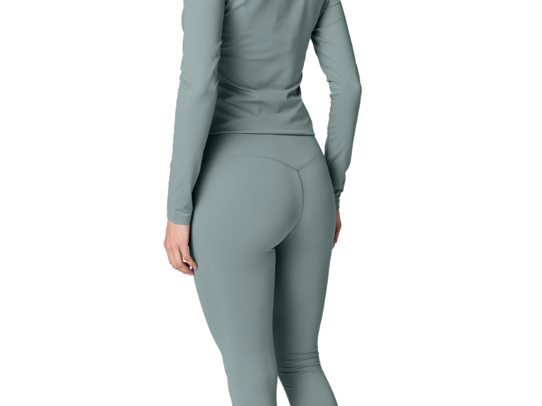 Frau in graublauem Langarmshirt und passenden Leggings, von hinten gesehen.